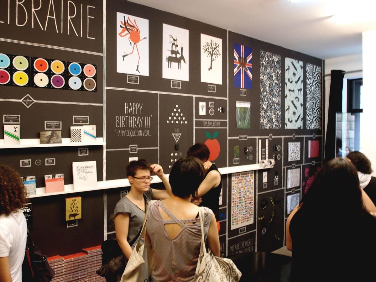 Exposition à la galerie SometimesStudio, Ichetkar présente dans une salle recouverte de papier peint tous ces produits accrochés au mur. Scénographie IchetKar