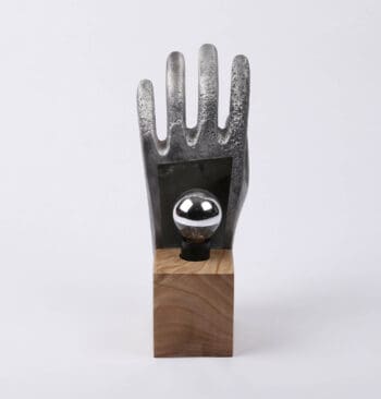 Ichetkar donne vie à une lampe singulière en utilisant un moule de gants, créant une main où les éléments chauds et froids fusionnent harmonieusement.