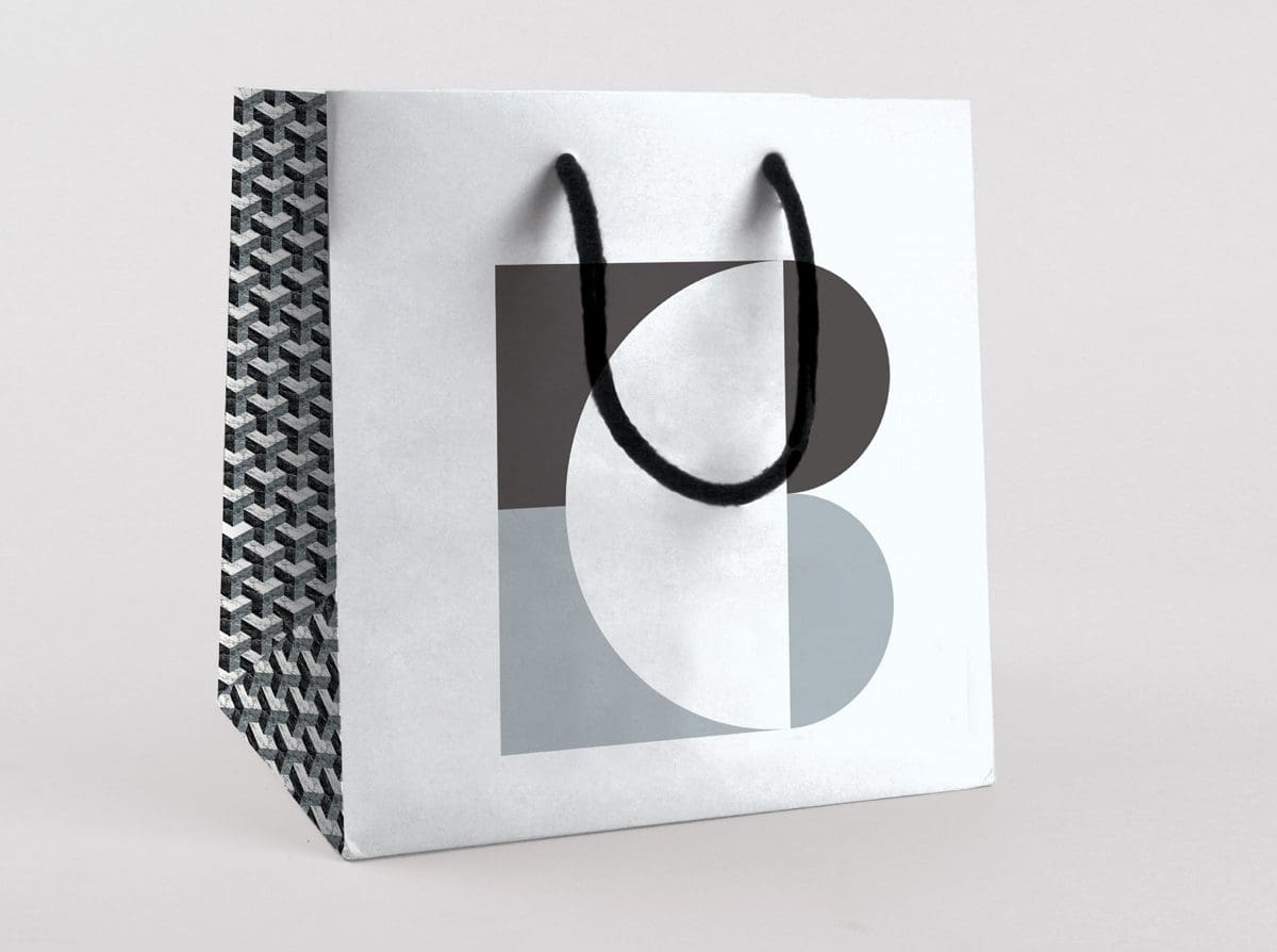 Sac en papier du marbrier Blanc Carrare. Couleurs noir, blanc et gris, inspirés du marbre et de la lave. Design Ich&Kar.